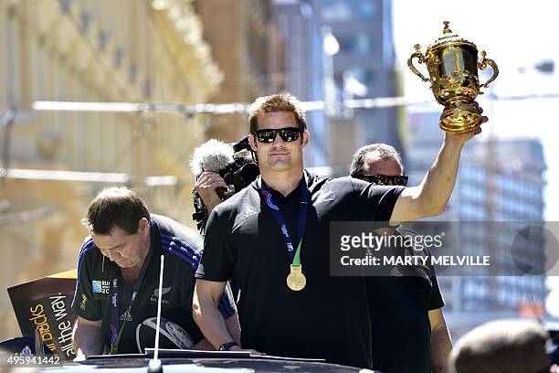 New Zealand's All Blacks rugby team captain Richie McCaw holds the Webb Ellis Cup during a parade by the team through the central business district...