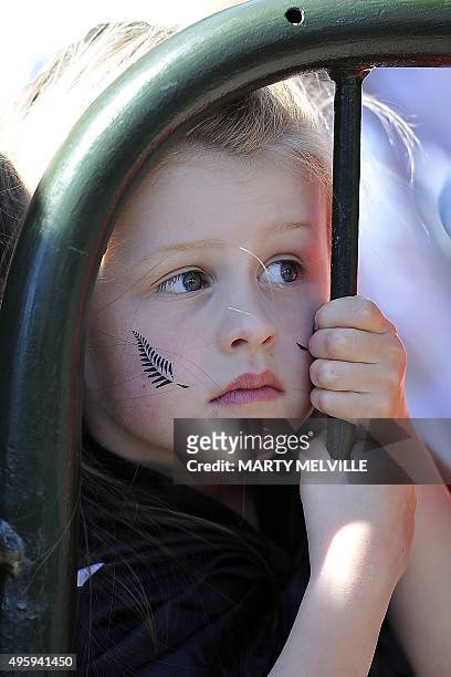 Young fan waits for New Zealand's All Blacks rugby team during a parade through the central business district of Wellington on November 6 following...
