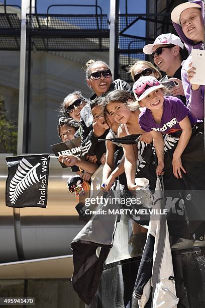 Fans wait for New Zealand's All Blacks rugby team during a parade through the central business district of Wellington on November 6 following their...