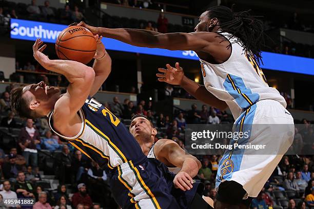 Gordon Hayward of the Utah Jazz is fouled by Kenneth Faried of the Denver Nuggets while taking a shot at Pepsi Center on November 5, 2015 in Denver,...