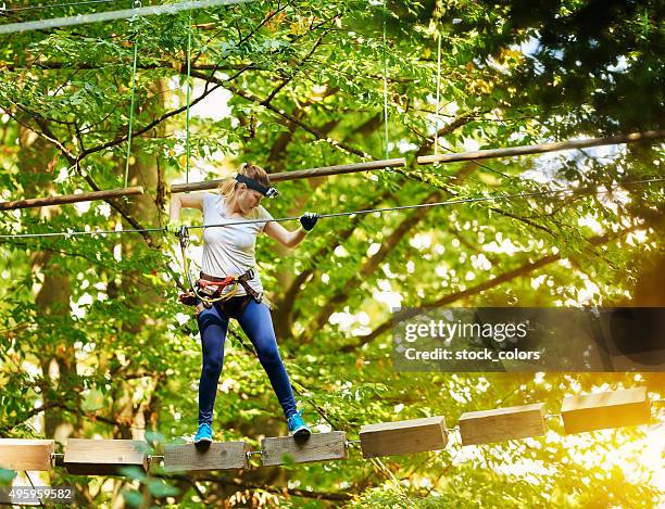 genauigkeit und kompetenz für dieses abenteuer - woman climbing rope stock-fotos und bilder