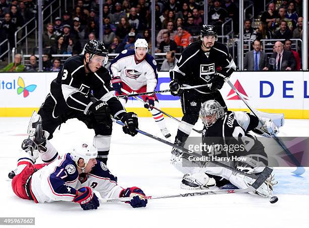 Jonathan Quick of the Los Angeles Kings makes a save on Brandon Dubinsky of the Columbus Blue Jackets as Brayden McNabb reaches to clear the rebound...
