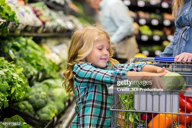 menina ajudando a mãe para comprar produtos na loja de mercearia - mother food imagens e fotografias de stock