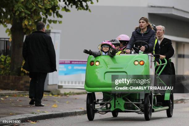 Children ride the "S'Cool Bus" in Rouen, northwestern France, on November 6, 2015. The "S'Cool Bus" transports pupils from their home to school. AFP...