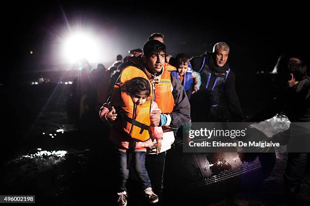 Refugees from Afghanistan and Syria arrive on a rubber boat with assistance of a fishing boat and the search light of a Greek coast guard vessel at...