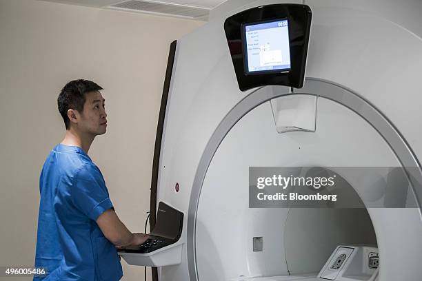 Technician checks a General Electric Co. Magnetic resonance imaging scanner in the diagnostic imaging area at the Hong Kong Integrated Oncology...