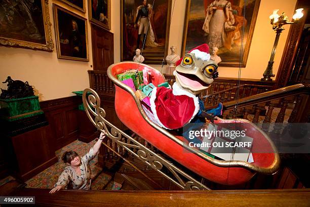 Staff member watches as a Christmas display of Mr Toad, a character from the classic children's book 'The Wind in the Willows', sat in a sleigh is...