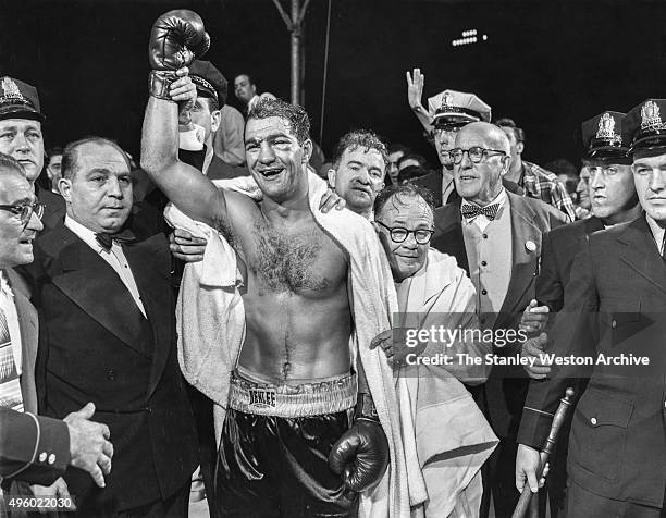 The winner and new World Heavyweight Champion Rocky Marciano by virtue of a 13th round knockout poses for a portrait. Looking over Marciano's...