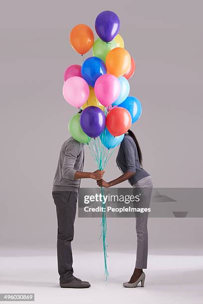 stealing a kiss behind the balloons - couple dark background bildbanksfoton och bilder