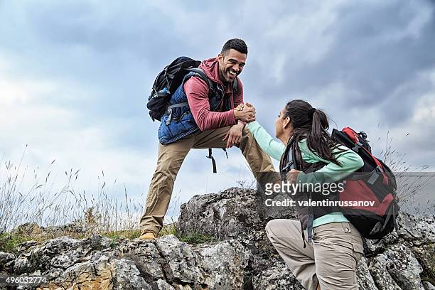 man and woman help on the rocks - help single word stock pictures, royalty-free photos & images