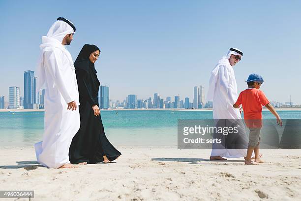 emirati family enjoying at beach - muslim woman beach stock pictures, royalty-free photos & images