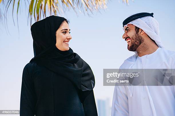 feliz casal desfrutando árabes na praia - muslim woman beach - fotografias e filmes do acervo