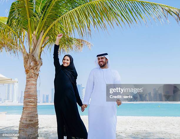 happy arab couple enjoying at beach - saudi arabia beach stock pictures, royalty-free photos & images