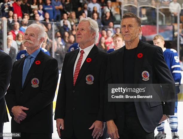 Hall of Fame members Lanny McDonald, Darryl Sittler and Borje Salming stand at attention during the national anthem prior to the game between the...