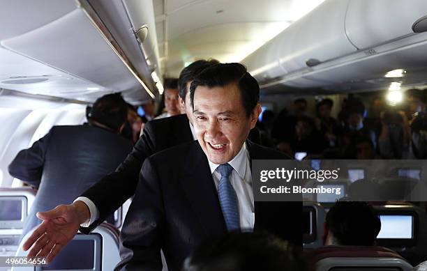 Ma Ying-jeou, Taiwan's president, center, greets members of the media traveling with him as he heads to Singapore for a summit on a chartered China...