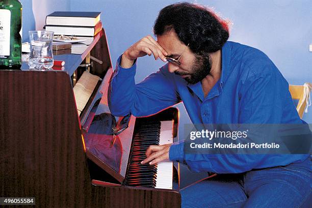 The Italian songwriter Antonello Venditti sitting in profile while playing a piano. Italy, 1984