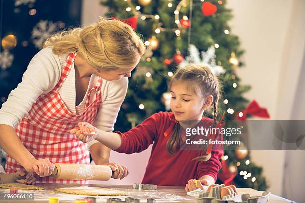 mother and daughter baking christmas cookies - rolling stock pictures, royalty-free photos & images