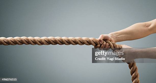 the hands of man pulling the rope - ziehen stock-fotos und bilder