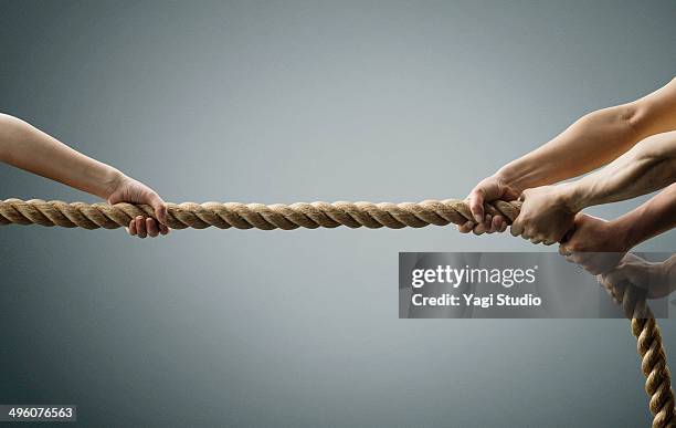 hand each other pull the rope - arrastrar fotografías e imágenes de stock