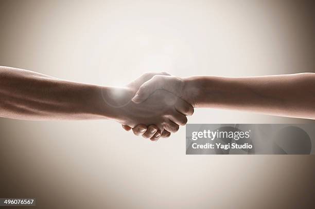the hands of men and women holding hands - lens flare white background stock pictures, royalty-free photos & images