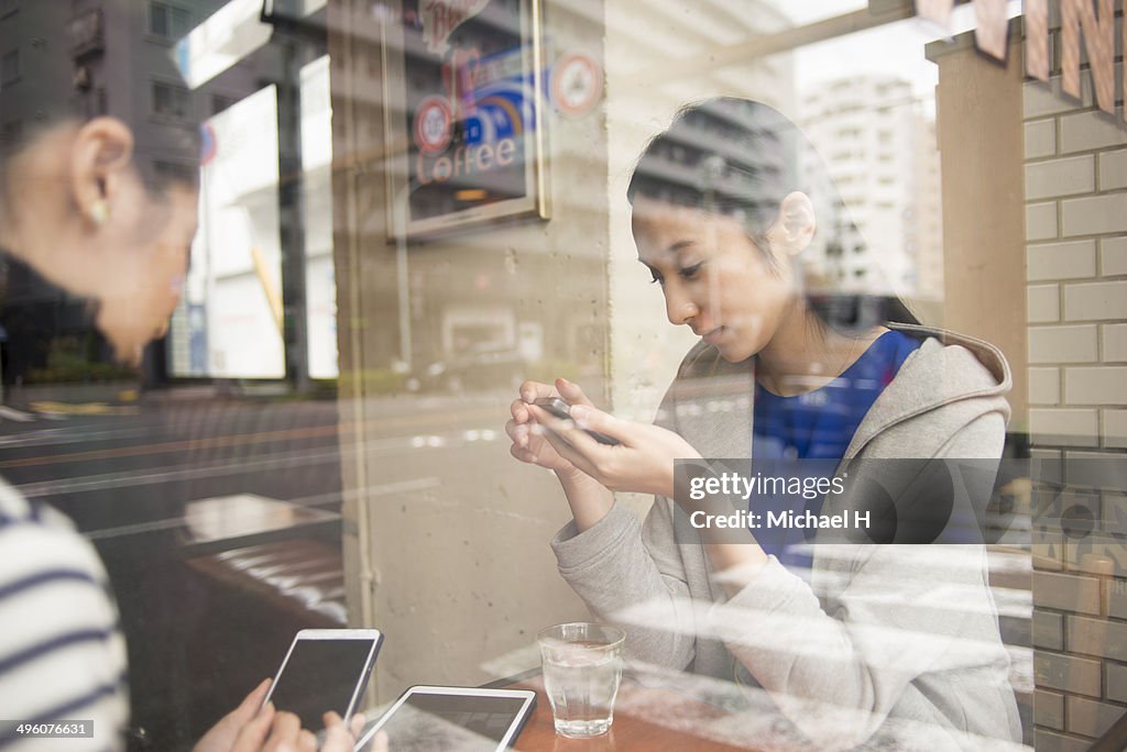 Friends talking with smartphones at  cafe