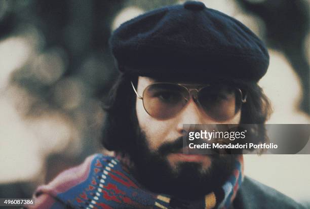 Close-up of the Italian songwriter Antonello Venditti posing with a hat and a scarf during a photo shoot. Italy, 1976
