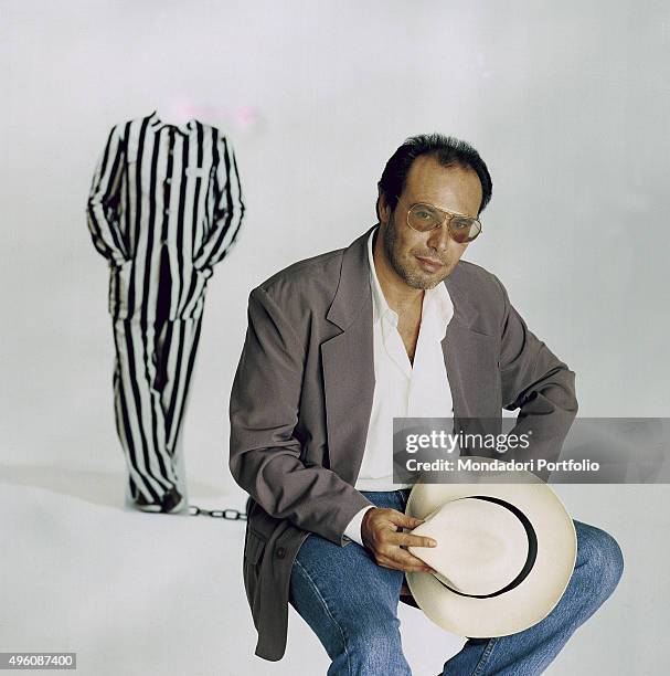 The Italian songwriter Antonello Venditti posing seated with a hat in his hand during a photo shoot realized for the album In questo mondo di ladri....