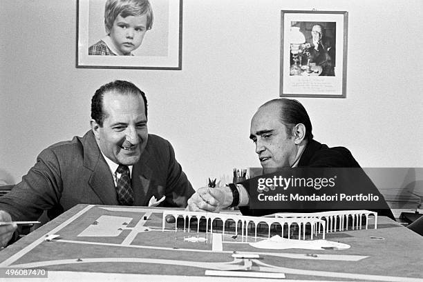 Brazilian architect Oscar Niemeyer showing to another man the Palazzo Mondadori scale model. The Italian publisher Giorgio Mondadori has recently...