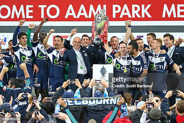 Kevin Muscat, coach of the Victory and Victory players celebrate after being presented with the FFA Cup after winning the FFA Cup Final match between...