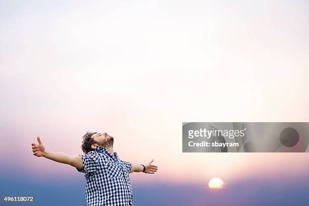 若い男性、腕を上げる - thankful man ストックフォトと画像