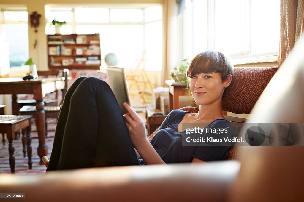 Young woman relaxing at home with tablet