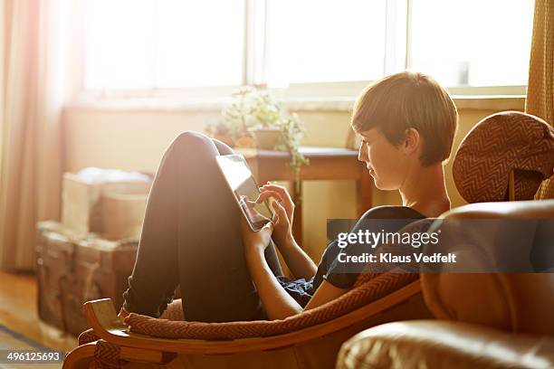 young woman relaxing at home with tablet - cosy woman stock pictures, royalty-free photos & images