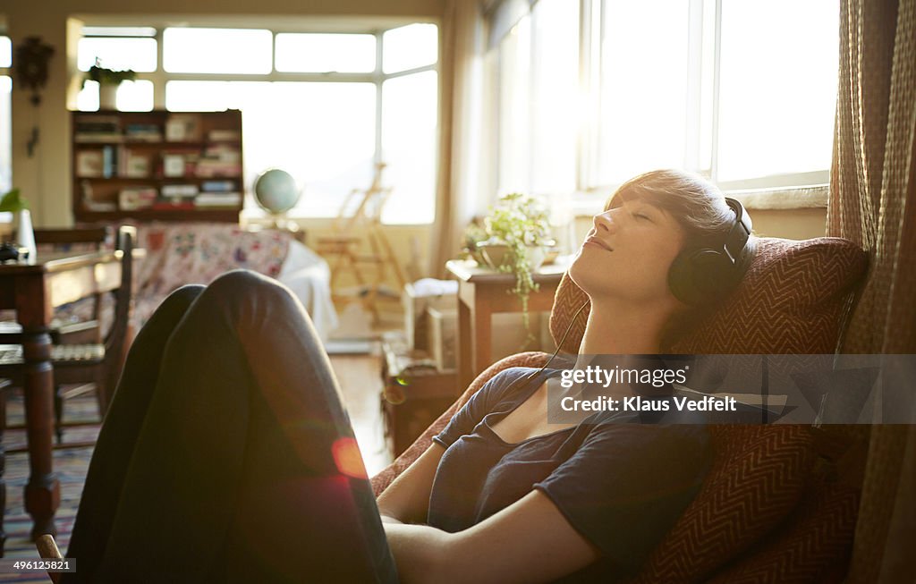 Young woman relaxing with headphones at home