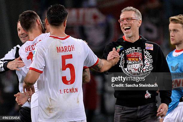 Dominik Maroh of Koeln is hugged by head coach Peter Stoeger after the Bundesliga match between Bayer Leverkusen and 1. FC Koeln at BayArena on...