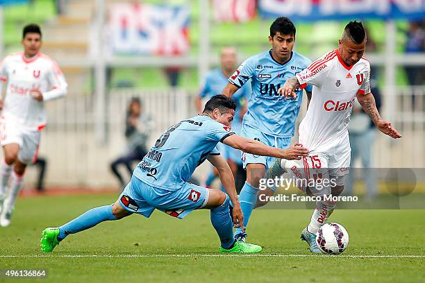 Leonardo Valencia of U de Chile fights for the ball with Cristian Oviedo of Deportes Iquique during a match between Deportes Iquique and U de Chile...