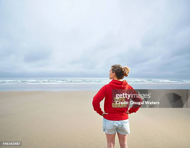 female life guard looking out to sea. - rettungsschwimmer stock-fotos und bilder