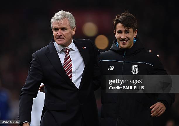 Stoke City's Welsh manager Mark Hughes celebrates with Stoke City's Spanish striker Bojan Krkic as they leave the pitch after the English Premier...