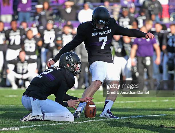 Jack Mitchell of the Northwestern Wildcats kicks the game-winning field goal out of the hold of Christian Salem against the Penn State Nittany Lions...