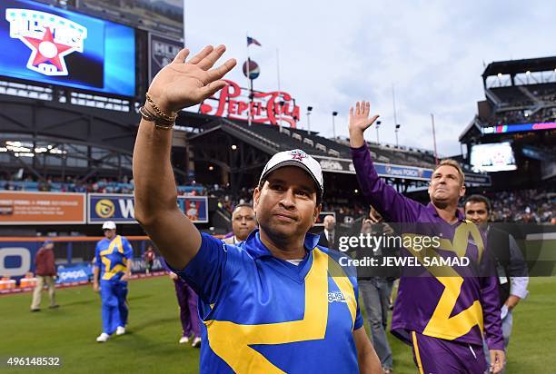 Sachin's Blasters captain Sachin Tendulkar and Warne's Warrors captain Shane Warne wave at fans at end of the first of a three-match T20 series at...