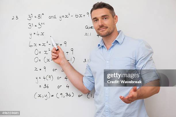 male teacher at whiteboard in classroom - lecturer whiteboard stock pictures, royalty-free photos & images