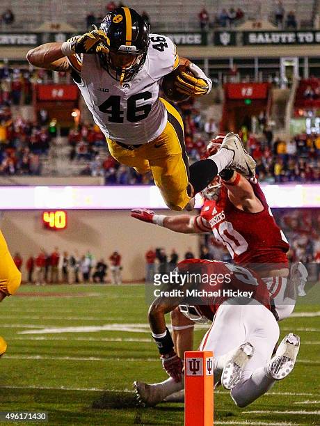 George Kittle of the Iowa Hawkeyes dives into the end zone for a touchdown over Jonathan Crawford of the Indiana Hoosiers at Memorial Stadium on...