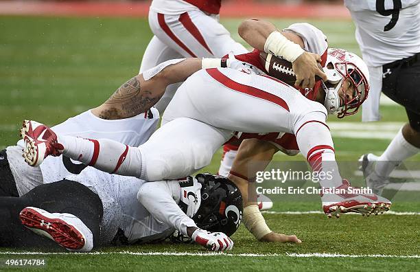Kenneth Farrow of the Houston Cougars is tackled by Jaylyin Minor of the Cincinnati Bearcats in the second quarter of a NCAA football game at TDECU...