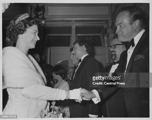 Queen Elizabeth II shaking hands with Bob Hope, with Mireille Mathieu, Ken Dodd and Harry Secombe in the background, at the Royal Variety...