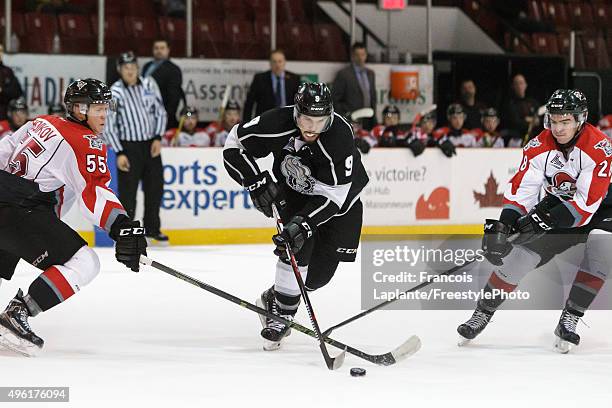 Yan Pavel Laplante of the Gatineau Olympiques controls the puck against Sergei Boikov and Frederic Aube of the Drummondville Voltigeurs on November...