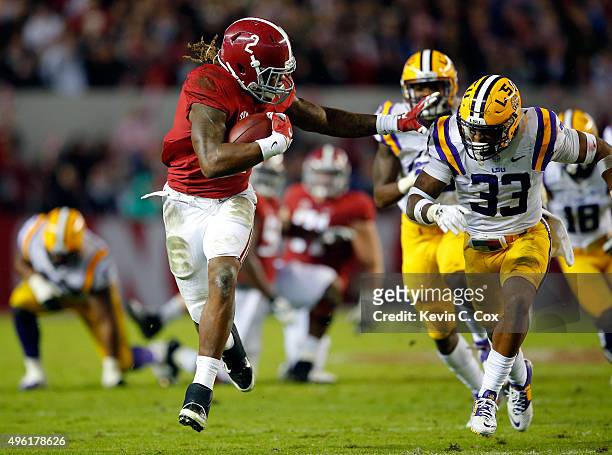 Derrick Henry of the Alabama Crimson Tide rushes away from Jamal Adams of the LSU Tigers in the second quarter at Bryant-Denny Stadium on November 7,...