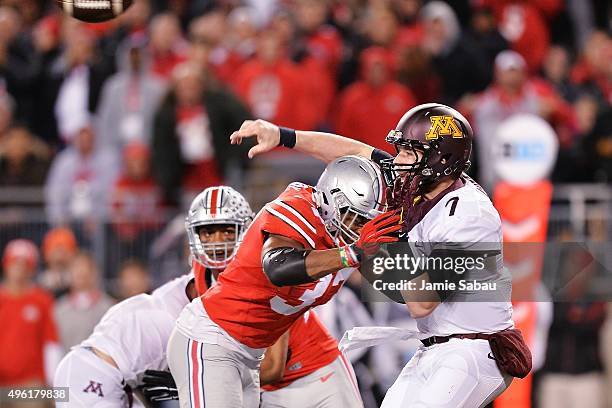 Joshua Perry of the Ohio State Buckeyes hits quarterback Mitch Leidner of the Minnesota Golden Gophers just as Leidner releases the ball forcing him...