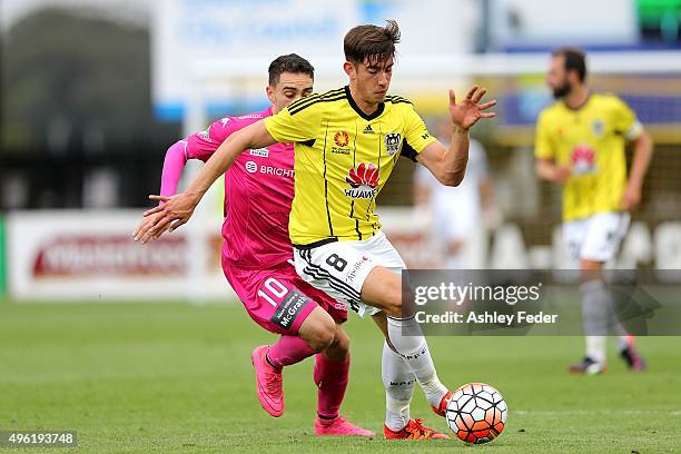 Alex Rodriguez of the Phoenix runs the ball ahead of Nick Montgomery of the Mariners during the round five A-League match between the Central Coast...