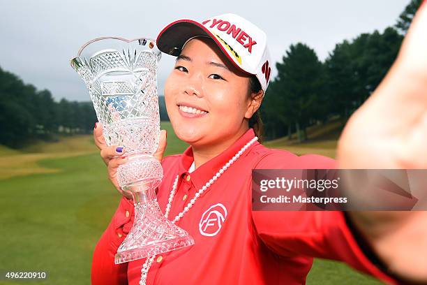 Sun-Ju Ahn of South Korea imitates a 'selfie' as she poses with the trophy after winning the TOTO Japan Classics 2015 at the Kintetsu Kashikojima...