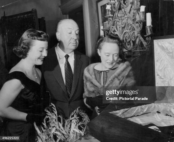 Film director Alfred Hitchcock with his wife and daughter Patricia, attending a haunted house party, circa 1960-1965.