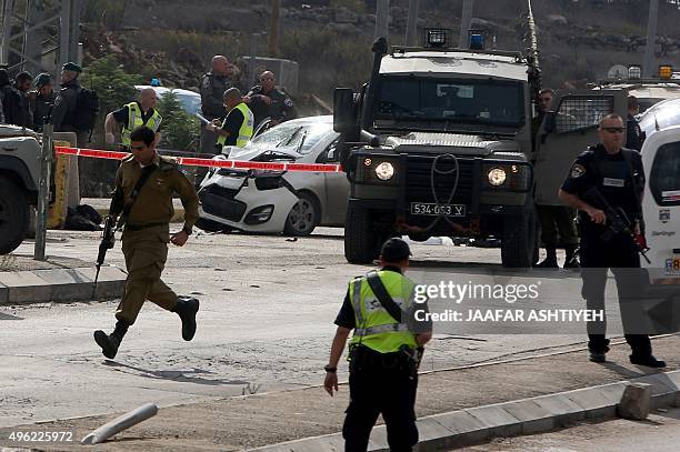 Israeli security forces gather at the scene where a Palestinian man was shot dead by security forces after ramming his car into a group of Israelis...